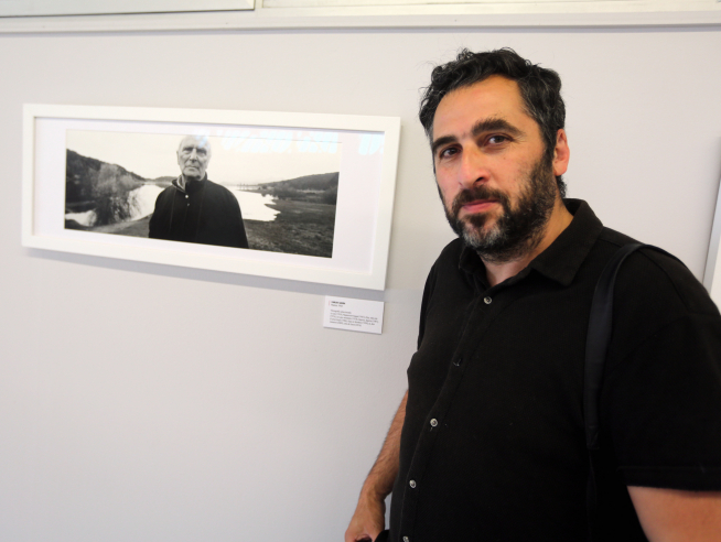 Óscar Fernández junto al retrato de Carlos Saura