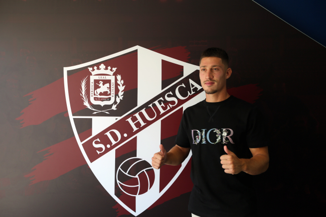 Enzo Lombardo junto al escudo del club.