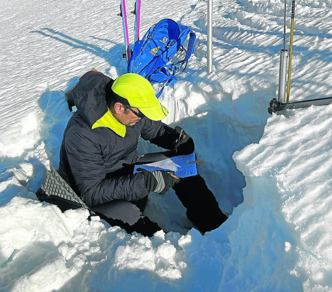 Trabajos para comprobar el estado de la nieve a partir de un corte junto al refugio.