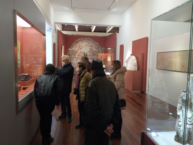 Blanca Solanas atiende a visitantes ante la arqueta de Buira.