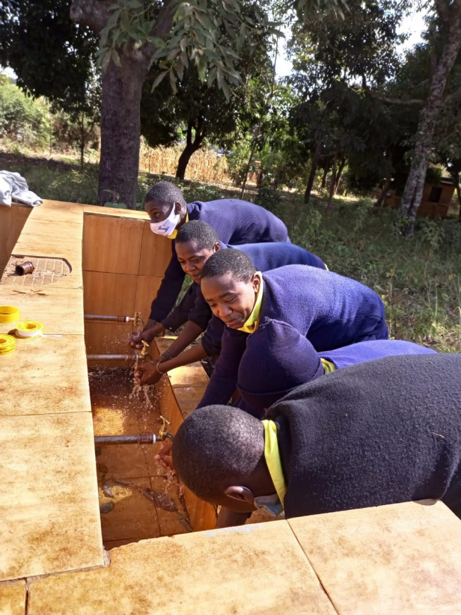 Escolares kenianos lavan sus manos en una de las fuentes de agua que se han construído gracias a la potabilizadora.