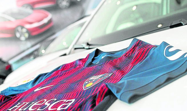 La camiseta de la SD Huesca sobre uno de los coches de Automóviles Cabrero, durante el acto.