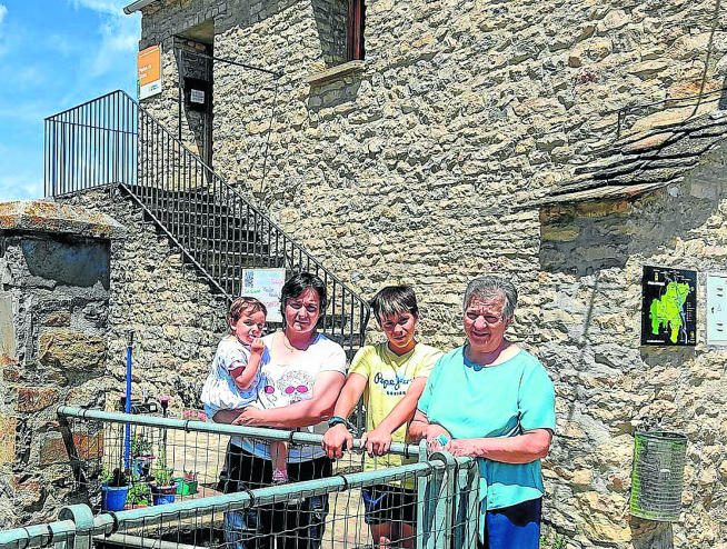 Milagros, con su hija Laura en brazos, su hijo Miguel y su madre Milagros, tres generaciones de la escuela de Paúles de Sarsa.