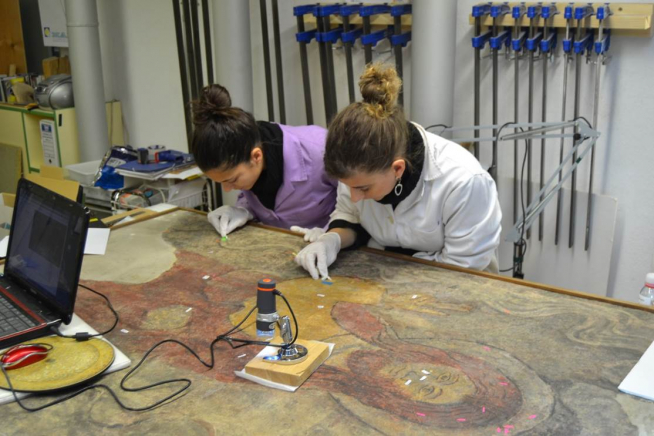 Alumnas de la Escuela Superior de Conservación y Restauración de Aragón, trabajando sobre una obra pictórica.