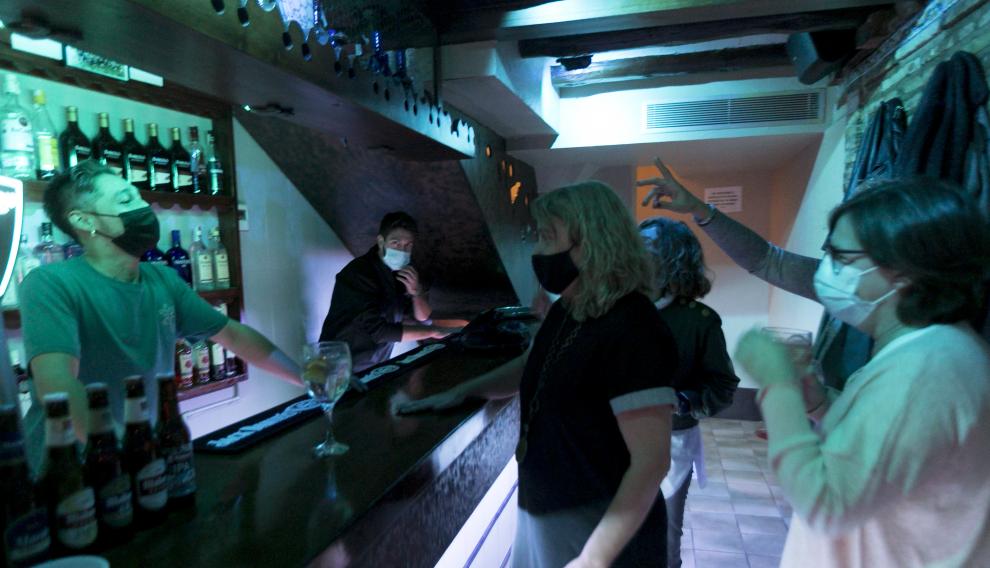 Un grupo de amigas, en la barra de un bar de copas a primera hora de la noche del sábado al domingo.