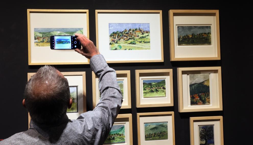 Un visitante inmortaliza algunas de las obras de la exposición.