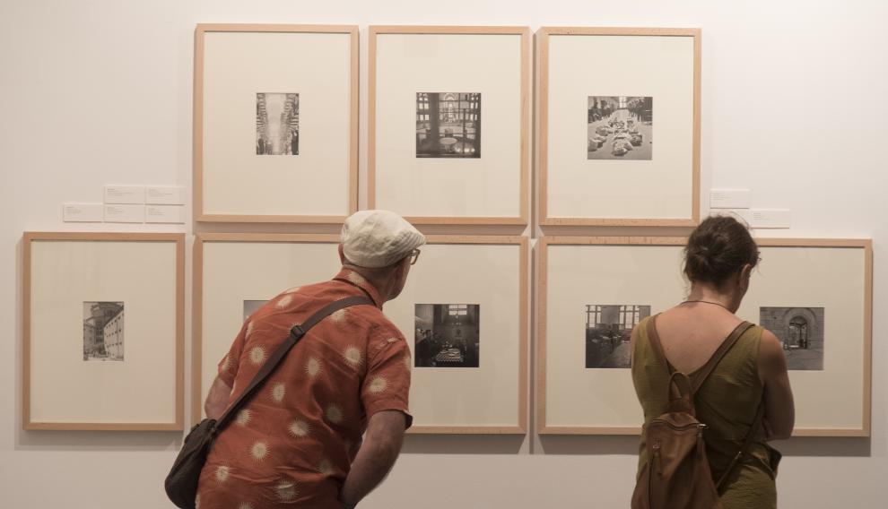 Imagen de visitantes admirando algunas de las fotografías exhibidas.