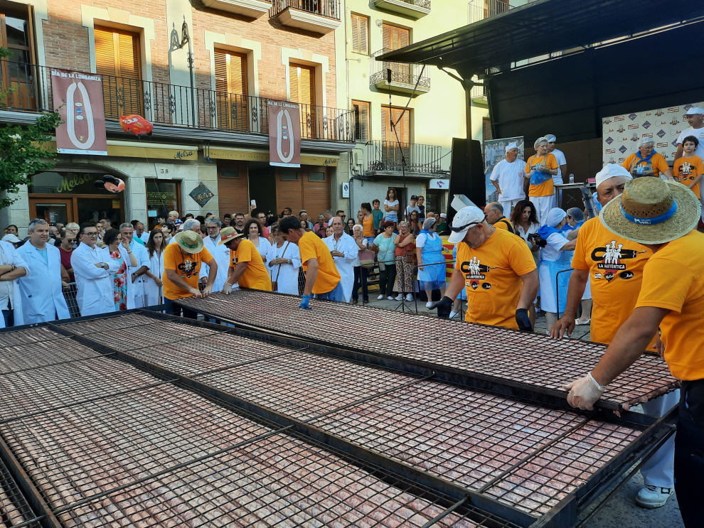 Graus atrae a millares de personas en torno a la 32ª edición de la Fiesta de la Longaniza, organizada por las empresas grausinas Aventín, Melsa y Maella. El público anima a las mujeres en la elaboración bajo un sol de justicia, disfrutando del aroma a brasa en el asado, con “el baile” de la parrilla en el cielo del atardecer. La longaniza, en su punto, estaba “deliciosa”, según el tastador, Enrique Serbeto.