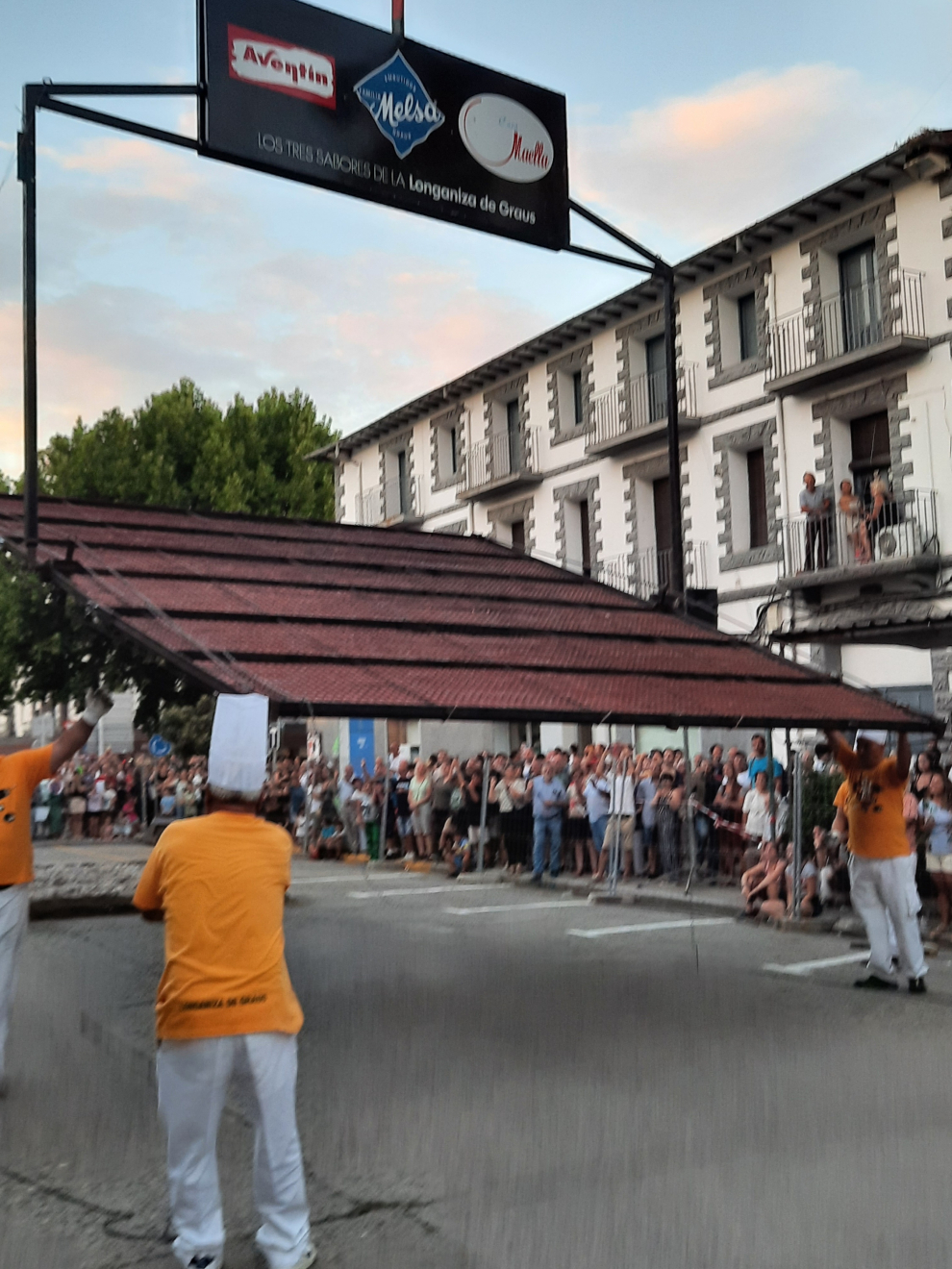 Graus atrae a millares de personas en torno a la 32ª edición de la Fiesta de la Longaniza, organizada por las empresas grausinas Aventín, Melsa y Maella. El público anima a las mujeres en la elaboración bajo un sol de justicia, disfrutando del aroma a brasa en el asado, con “el baile” de la parrilla en el cielo del atardecer. La longaniza, en su punto, estaba “deliciosa”, según el tastador, Enrique Serbeto.