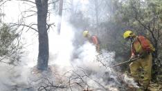 Trabajos de una cuadrilla de bomberos en la extinción de un incendio forestal en Aragón