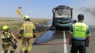 Bomberos y Guardia Civil junto al camión incendiado en Fraga.