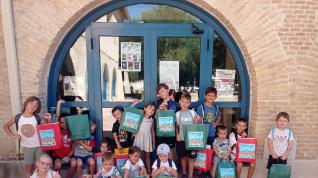 Un grupo de niños, con su bolsa de ‘Veraleo’, en la puerta de la biblioteca.