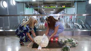 Varias personas depositan flores durante el acto de homenaje por el 15º aniversario de la tragedia de Spanair, en la placa conmemorativa de la Terminal 2.