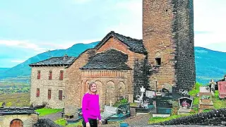 Mónica Ara, directora de la oficina de Caja Rural de Aragón en Jaca junto a la iglesia de su pueblo: Oliván