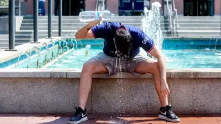 Un joven se tira una botella de agua por encima para combatir la segunda ola de calor del verano. FOTO