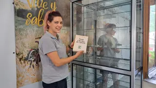 Marta Luis con el libro referente de Luis Fernandez Fuster y la vitrina donde se expondrá.
