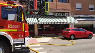 Efectivos de bomberos ante la tienda donde se ha producido el incendio