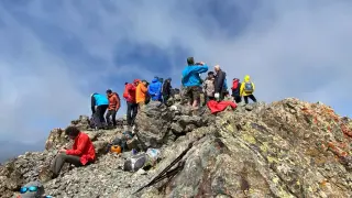 Los montañeros reponen fuerzas y charlan en la cima del pico de la Gran Facha.