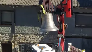 Arcusa coloca la recién restaurada campana de San Esteban.