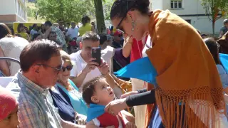 Una Serrablesa coloca una pañoleta a un bebé en el acto celebrado ayer.
