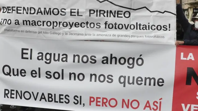 Representantes de las diferentes plataformas comarcales mostraron pancartas contra los macroparques solares a las puertas de la Catedral de Jaca.