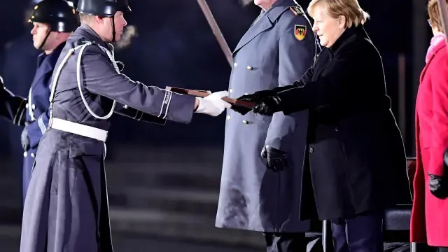 Angela Merkel fue despedida ayer por el Ejército alemán en una ceremonia con antorchas.