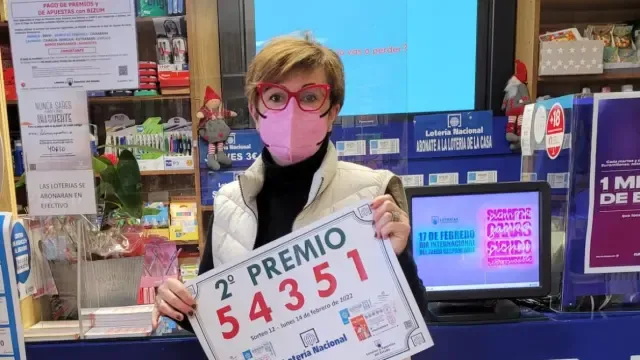 Marisa Escartín sostiene un cartel con el número premiado.