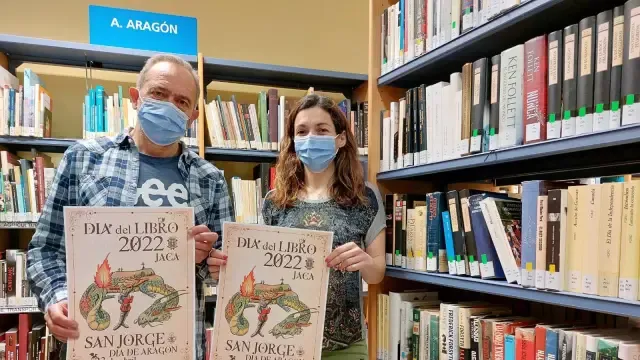 Los concejales de Cultura, Javier Acín, y de Juventud, Laura Climente, con el cartel del programa del Día del Libro, en la Biblioteca de Jaca.