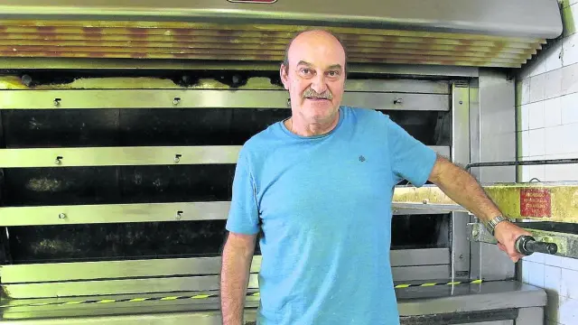 Pedro Palomar frente al horno de piedra refractaria en el que cuece el pan que ahí fabrican.