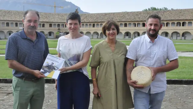 Francisco Rubio, Lydie Althapé, Marie Pacheco y Cédric Pucheu, en la Ciudadela de Jaca, mostrando un queso y el cartel de la nueva feria.