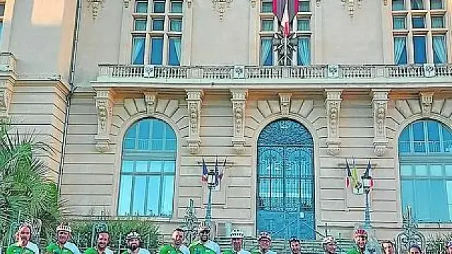 Los ciclistas oscenses posan delante del Ayuntamiento de Tarbes con la bandera francesa y la española.