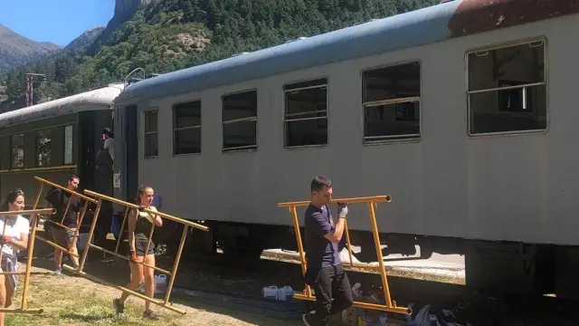 Jóvenes cargan material para la recuperación del vagón.