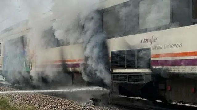 Labores de extinción del incendio en un tren de la línea Zaragoza-Lérida.