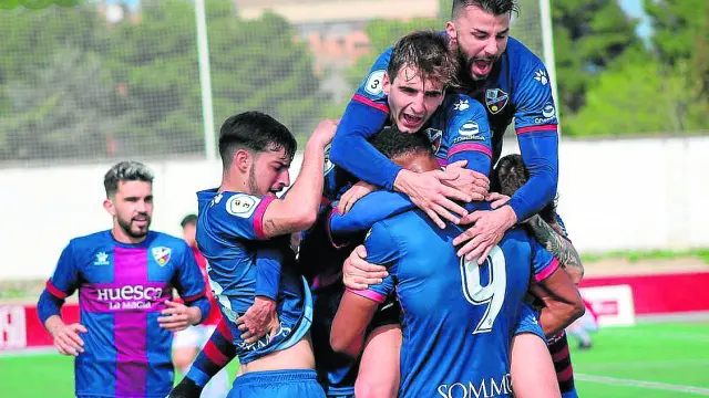 Los jugadores del Huesca B se abrazan con Carlos Kevin tras marcar el gol de la victoria.
