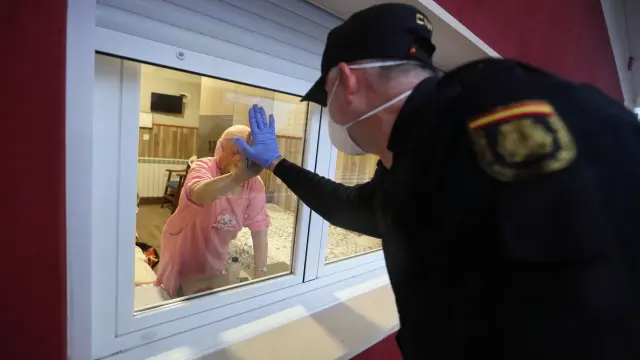 Un policía anima a una anciana en la residencia Los Olivos de Huesca, en la primera ola.