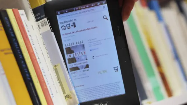 Una persona observa un libro electrónico en un estante de la Feria del Libro de Fráncfort (Alemania).