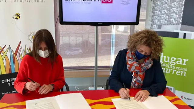 Carmen Fernández y Romy Piñeyroa firman el convenio entre ambas entidades.