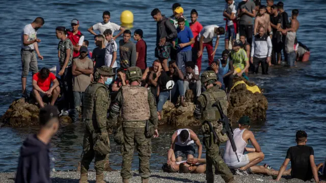 Soldados del Ejército de Tierra observando a un grupo de inmigrantes que llegaban a la costa de Ceuta.