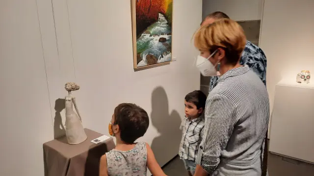 Una familia visitando la exposición en el Espacio Pirineos.