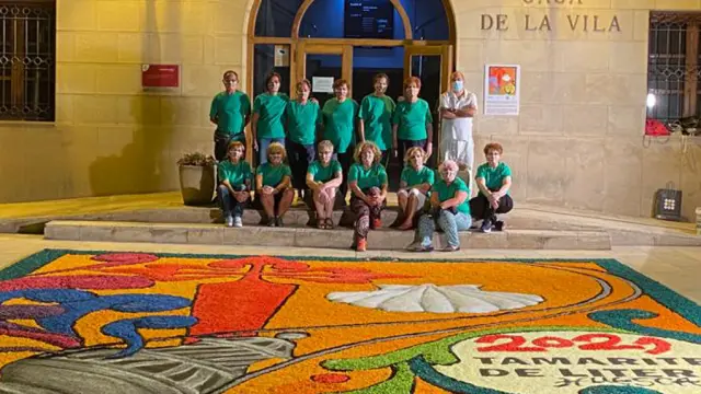 Grupo de alfombristas junto a la alfombra conmemorativa del Año Jacobeo 2021, en la plaza de España de Tamarite.