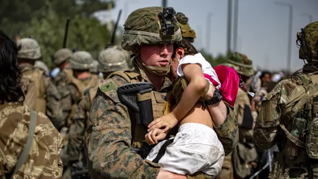 Un soldado transporta a un bebé en Afganistán.