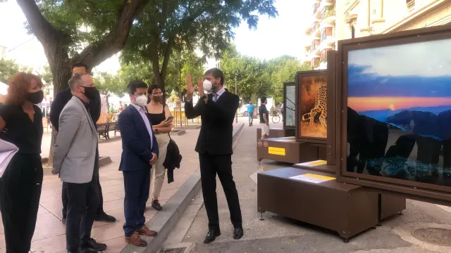 El comisario de la muestra (derecha), explicando las fotografías al alcalde y las autoridades.