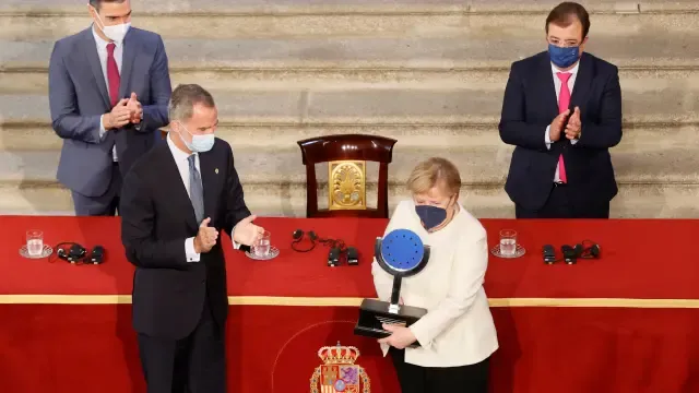 Angela Merkel muestra el XIV Premio Europeo Carlos V que recibió de manos de Felipe VI.