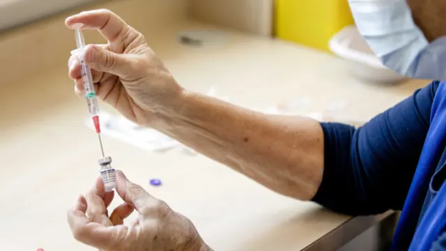 Un sanitario prepara una vacuna para ser inoculada ayer en el área de influencia de La Haya.