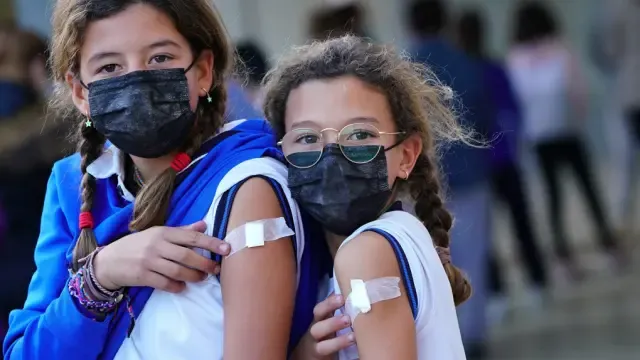 Dos niñas tras haber recibido la vacuna.