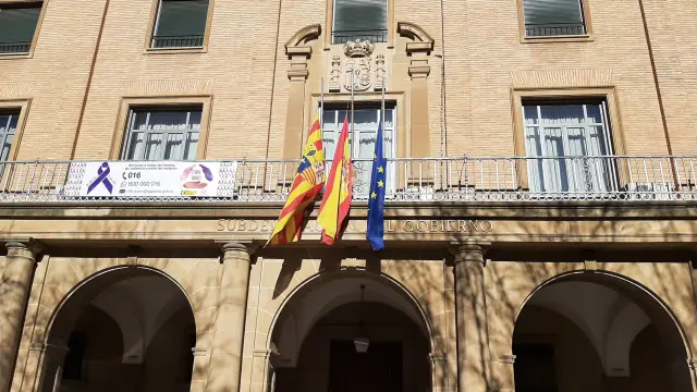 Imagen de la Subdelegación del Gobierno en Huesca con sus banderas a media asta.