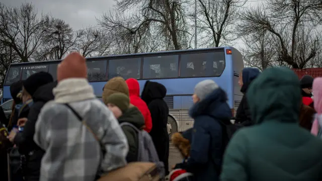 Varias personas y niños esperan para pasar a Rumanía desde Ucrania.