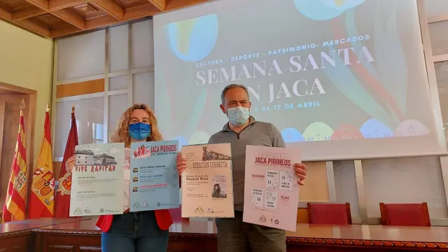 Olvido Moratinos y Javier Acín muestran los carteles de las actividades en el Salón de Ciento del Ayuntamiento de Jaca.