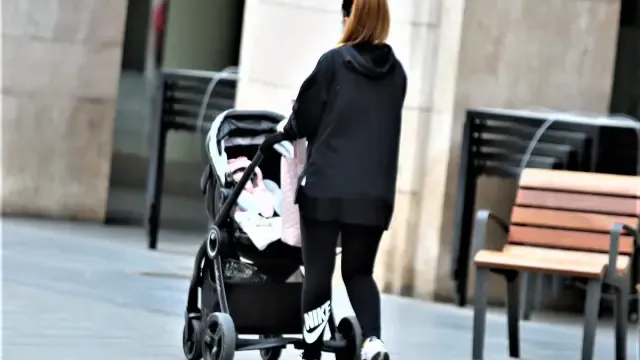 Foto de archivo de una joven paseando un bebé por el centro de Huesca.