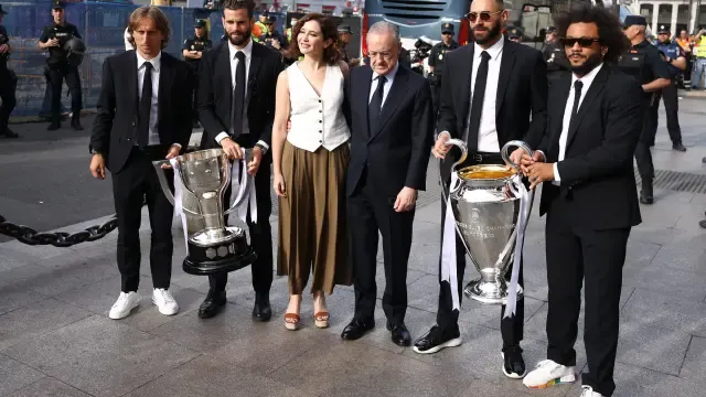 Jugadores del Real Madrid con Isabel Díaz Ayuso posan con la copa de la Champions.